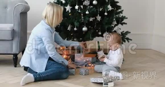 妇女和儿童在圣诞树下打开礼物视频