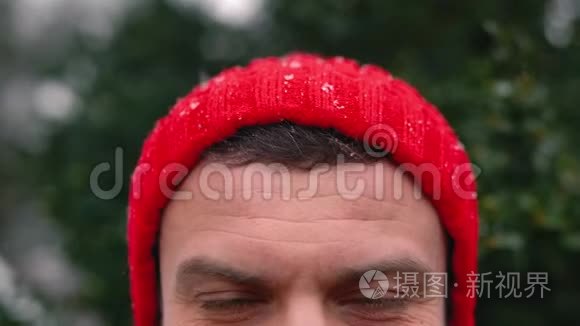 一个戴红帽子的男人在户外下雪时的肖像短视频