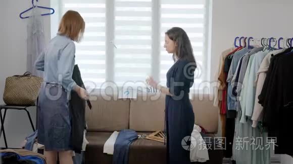 两个女女友拆开衣柜.. 女孩们试着穿不同的衣服，决定如何打扮。