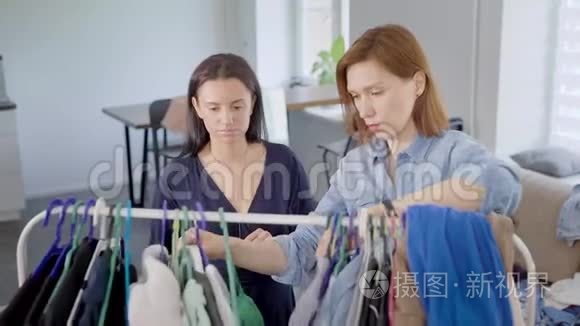 两个女女友拆开衣柜.. 女孩们试着穿不同的衣服，决定如何打扮。