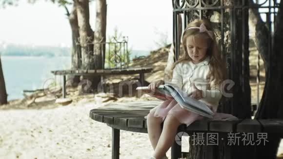 一个可爱的女孩坐在树林里看书