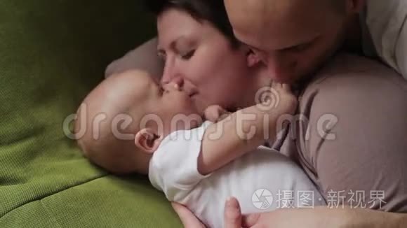爸爸妈妈和他的小儿子在床上玩。 幸福家庭概念