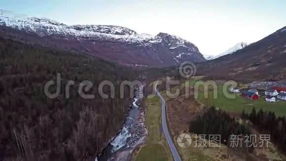 挪威景观的空中景观有洪水泛滥的河流，山顶上有雪的沼泽和绿色的田野