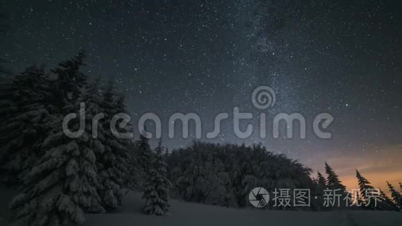 圣诞节的冬夜风景，星空在白雪皑皑的树木上移动。 天文时间流逝放大