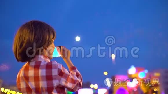 小男孩幼儿拍摄美丽烟花的图片在夜空中展示手机.. 宝宝的手