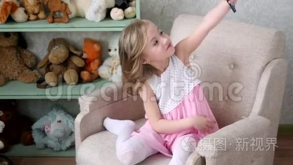 小女孩在家里用手机拍自拍照片视频