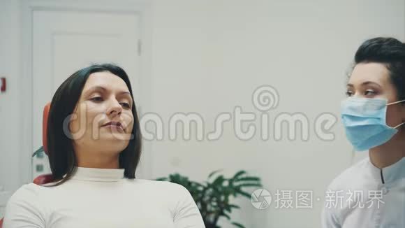 年轻的医生是一个穿着医用白色衣服和口罩的女人，做一个病人的回顾。 在考试期间