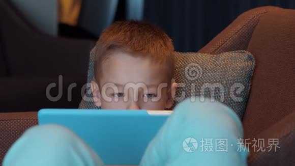 儿童躺在扶手椅上看动画片视频
