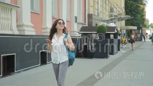 戴着太阳镜背包的女人在城里散步时很开心。
