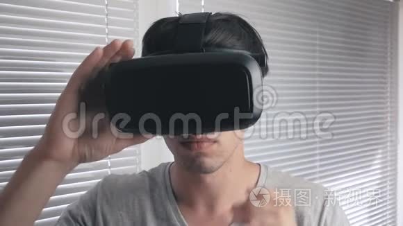 年轻人用他的VR耳机在办公室背景下观看360视频。 快关门。