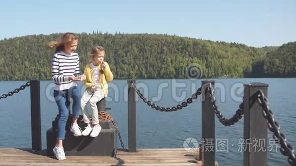 母亲和女儿坐在码头温暖的秋日视频