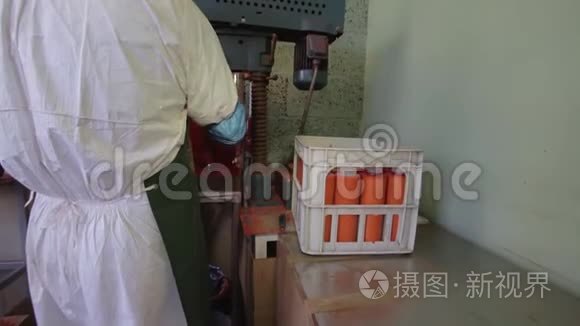 实验室操作人员穿着制服，把橙色塑料管从旋转机器中取出