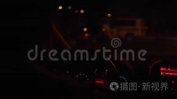 在漆黑的夜路上驾驶汽车时的人和方向盘