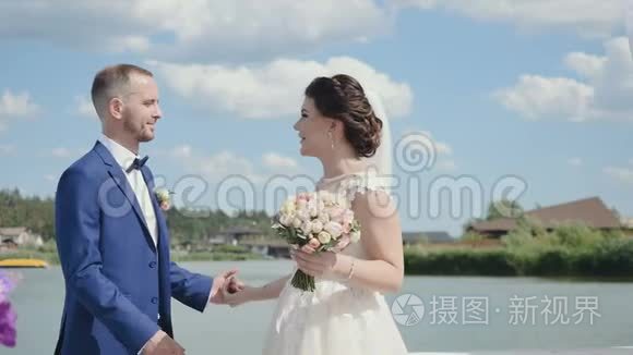 美丽的新婚夫妇在河边亲吻视频