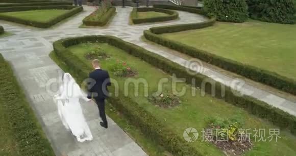 科普特对婚礼的看法。 新郎和新娘在森林环绕的大公园里散步