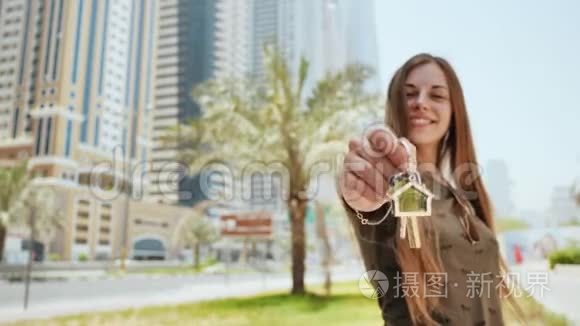 小女孩拿着钥匙。 在迪拜买公寓或汽车的概念。