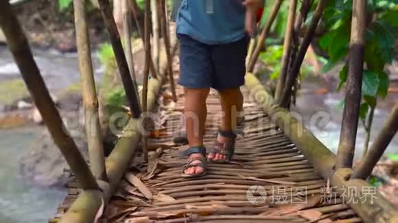 父亲在竹木桥上穿过热带河流视频