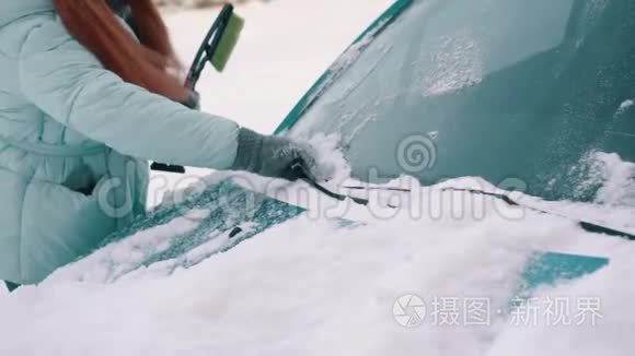 女人从汽车挡风玻璃上清除积雪视频