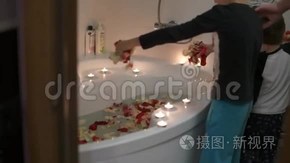 爸爸和两个儿子为妈妈准备一个惊喜。 他们在浴室点燃蜡烛，洒满玫瑰花瓣。