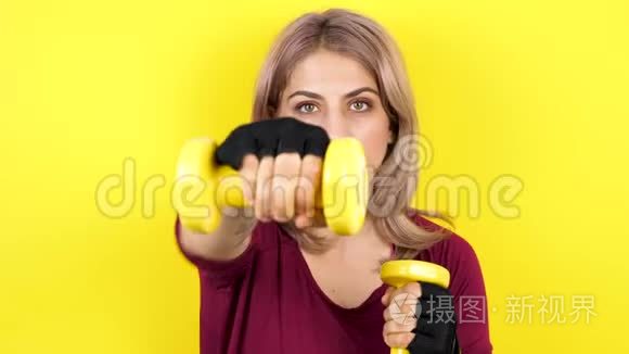 女子黄色背景练习哑铃运动视频