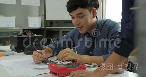 亚洲学生正在学习电子产品，并在教室里测量信号。