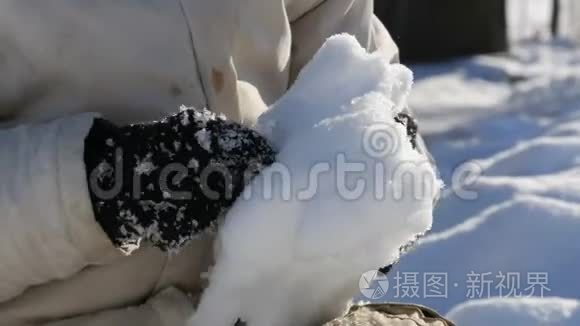 少年男孩玩雪，做雪球，冬天把雪扔在手里。 阳光明媚的冬日