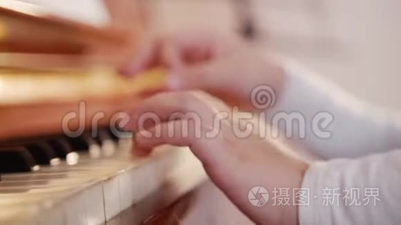 音乐课。 弹钢琴的女孩。 把琴键合上，孩子的手。 玩游戏的斜视图