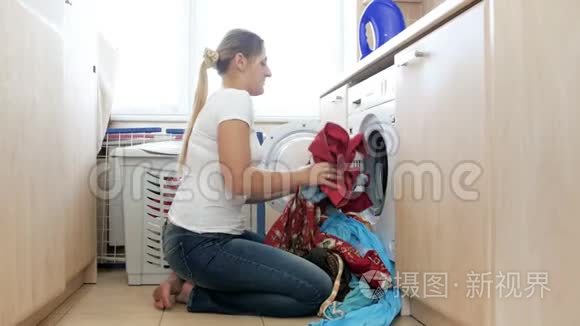 4k镜头，微笑的年轻女子装洗衣机，开始洗衣