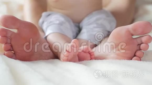 婴儿和他妈妈的腿在床上。 幸福的家庭观念。 美丽的产妇概念视频。