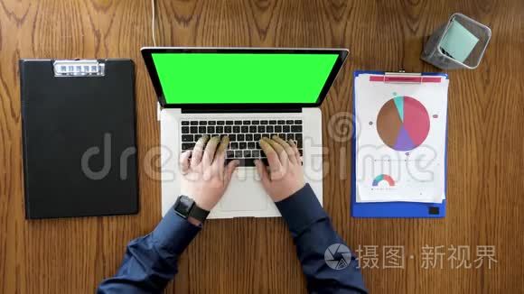 商人手在带有绿色屏幕的笔记本电脑上打字和滚动