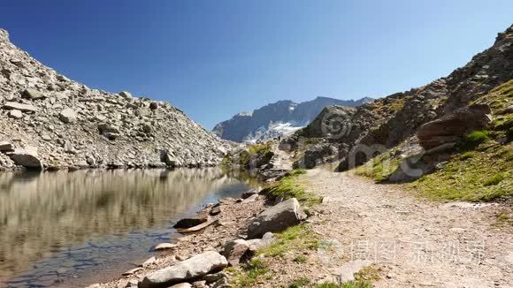 人在田园诗般的山景中，以晶莹的湖水高山峰和冰川行走。 夏日冒险