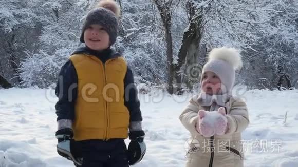 男孩和女孩看着雪从树上飘落视频