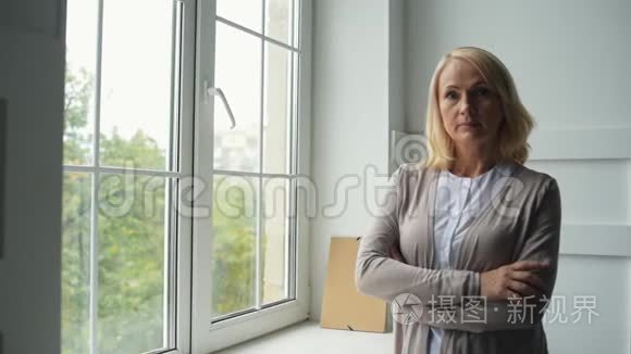 平静的中年妇女站在窗边视频