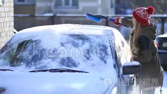 女人用刷子清理车顶上的积雪视频