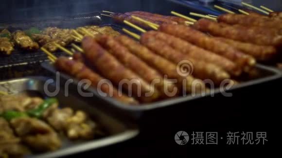 慢动作供应商在棍子上煮台湾鸡肉。 夜市街。