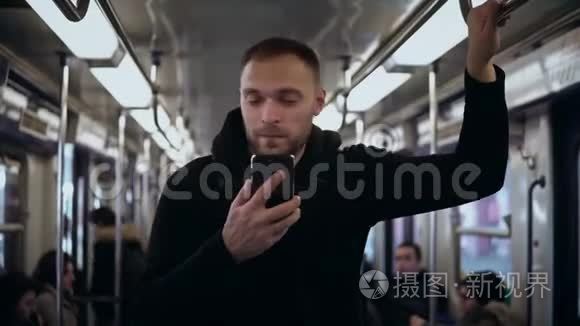年轻时尚的男人坐火车旅行，使用带有触摸屏的智能手机。 男性在地铁上网。