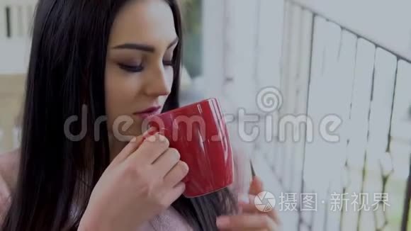 布鲁内特女孩喝红杯热茶视频