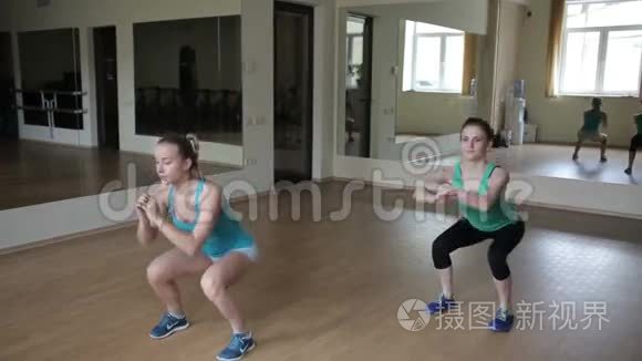 两个女孩蹲在健身房