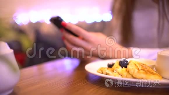 女人在食物的背景上用电话。 手机在女人手里。 女人在智能手机上打字。