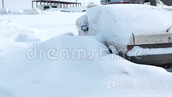 肮脏的白色汽车覆盖着城市的雪。 后景。