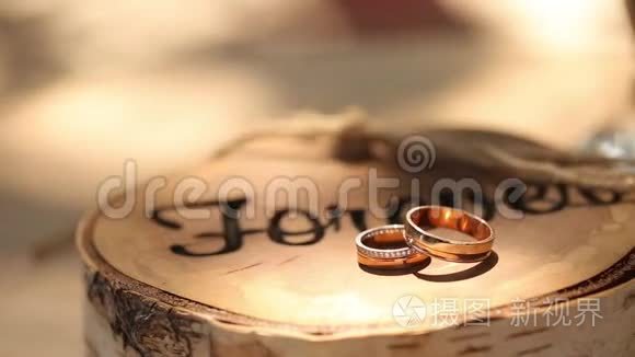 结婚戒指躺在树桩上，木制的乡村风格，铭文`永远`新郎和新娘的仪式上