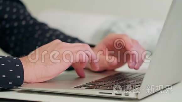 男人`手在笔记本电脑上打字。