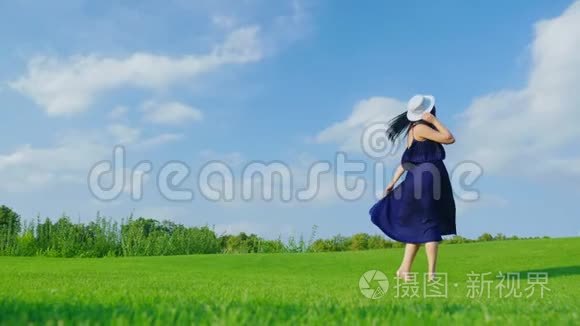 穿着浅色衣服的孕妇在绿色草地上玩得开心