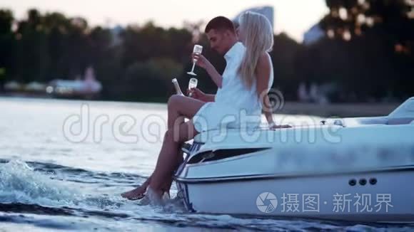 一对美丽的年轻夫妇在船上喝香槟