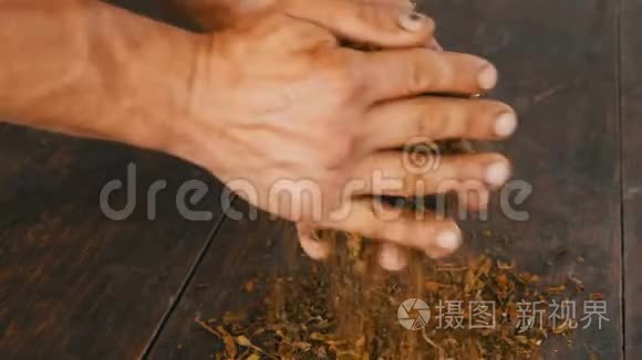 男性双手揉碎桌子上干燥的烟叶视频
