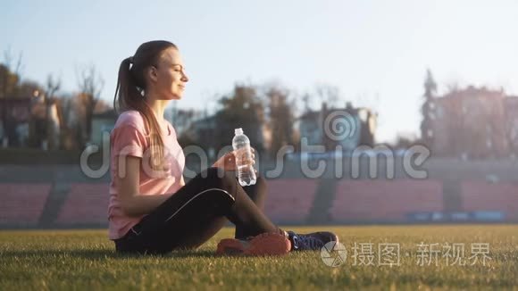 微笑的女孩在体育场喝水视频