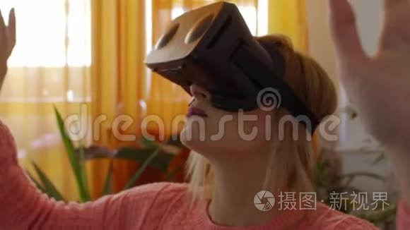 穿着粉红色毛衣的女人在家享受在现代扶手椅中使用虚拟现实护目镜