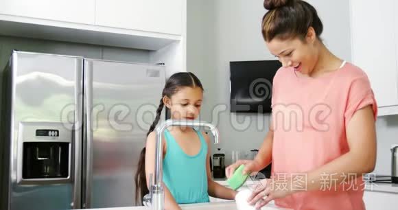 妈妈教女儿在厨房洗瓷器视频