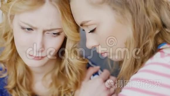 肖像年轻的女人安慰一个心烦意乱和哭泣的朋友。 青少年的支持和友谊问题