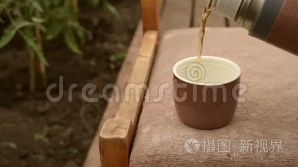 花园里倒着茶的热水瓶